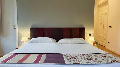 a large bed with a wooden headboard in a bedroom at NTB Roma B&B in Rome