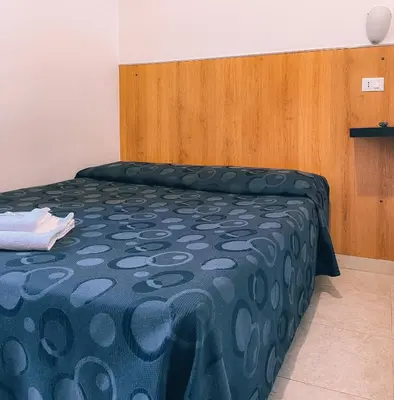 a bedroom with a bed with a blue comforter at Hotel Fiorenza in Rome