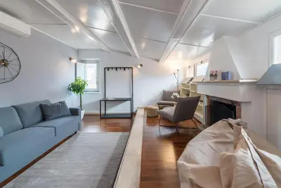 a living room with a blue couch and a fireplace at CS Campo de'Fiori - Navona Amazing Terrace Apartment in Rome