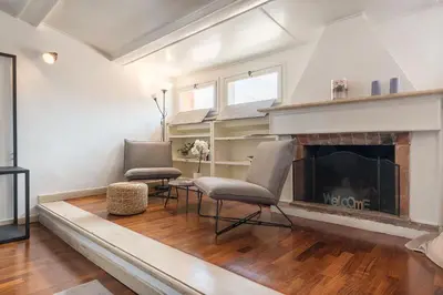 a living room with two chairs and a fireplace at CS Campo de'Fiori - Navona Amazing Terrace Apartment in Rome