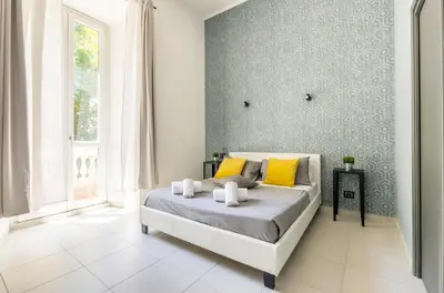 a bedroom with a bed with yellow pillows at Merulana 139 Suites in Rome