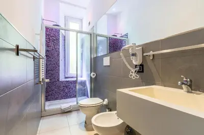 a bathroom with a toilet and a sink and a shower at Merulana 139 Suites in Rome
