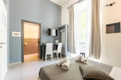 a bedroom with a bed and a table with chairs at Merulana 139 Suites in Rome