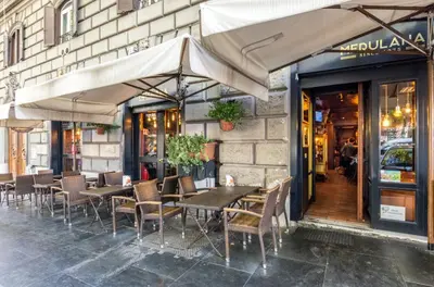 a restaurant with tables and chairs in front of a building at Merulana 139 Suites in Rome