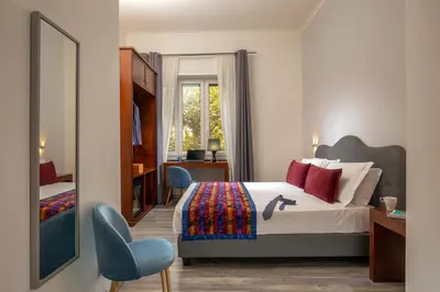 a bedroom with a bed and a desk and a chair at Prima Guest House Collection in Rome