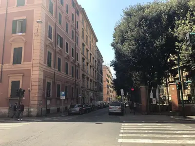 a street with cars parked on the side of a building at Colosseo Roma in Rome
