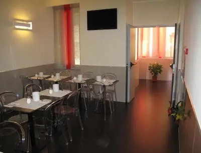 a room with tables and chairs and a flat screen tv at Colosseo Roma in Rome