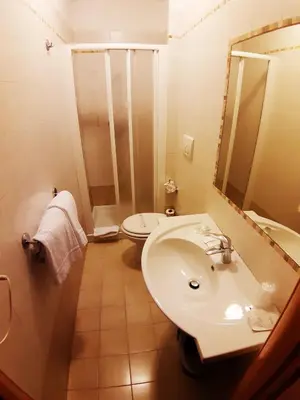 a bathroom with a sink and a toilet and a mirror at Colosseo Roma in Rome