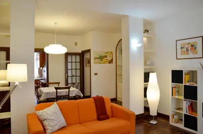 a living room with an orange couch and a dining room at Holiday in Rome in Rome