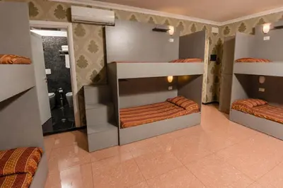 a room with three bunk beds and a bathroom at Hostel Beautiful in Rome