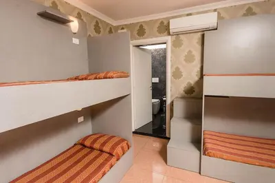 a bedroom with two bunk beds and a bathroom at Hostel Beautiful in Rome