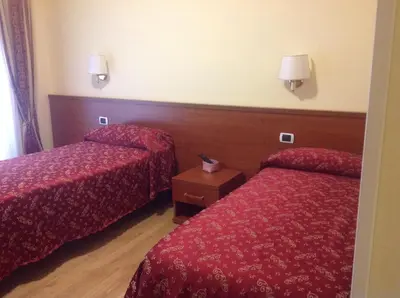 a hotel room with two beds with red sheets at Residenza Fermi in Rome