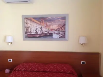a painting hangs above a bed in a hotel room at Residenza Fermi in Rome