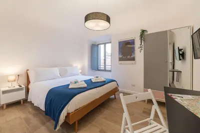 a bedroom with a large bed with a blue blanket at Roma Station House in Rome