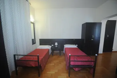 a room with two beds and a table in it at Hotel Beauty in Rome