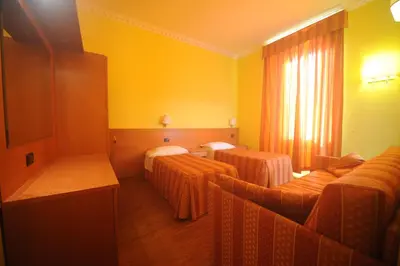 a hotel room with two beds and yellow walls at Hotel Beauty in Rome