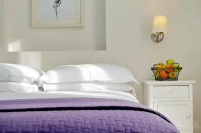 a bed with a purple blanket and a basket of fruit at Guest House Amaranto Romano in Rome