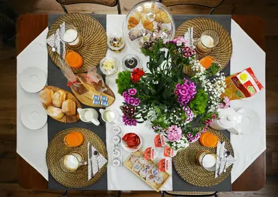 a table with a bunch of food and flowers on it at La Design.aTA Experience Bed & Breakfast in Rome