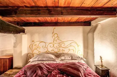 a bed with an ornate headboard in a bedroom at La Scala in Rome