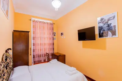 a bedroom with a bed and a tv on the wall at Flower guesthouse in Rome