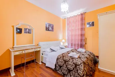 a bedroom with a bed and a dressing table and a mirror at Flower guesthouse in Rome