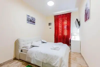 a bedroom with a white bed and a red curtain at Flower guesthouse in Rome