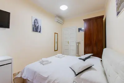 a bedroom with a white bed and a television at Flower guesthouse in Rome