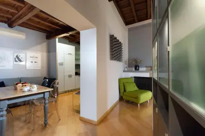 a dining room with a table and a green chair at Delle Grotte Apartment in Rome