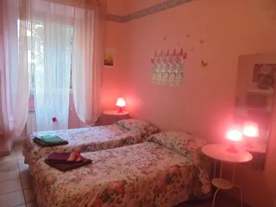 a bedroom with two beds and two lamps on tables at Max House in Rome