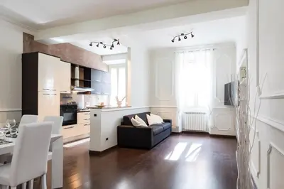 a living room with a black couch and a kitchen at Frattina Royal in Rome