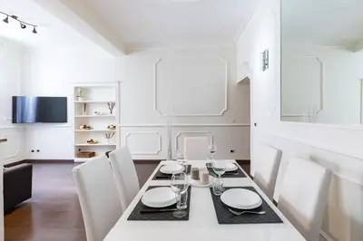 a white dining room with a table and chairs at Frattina Royal in Rome