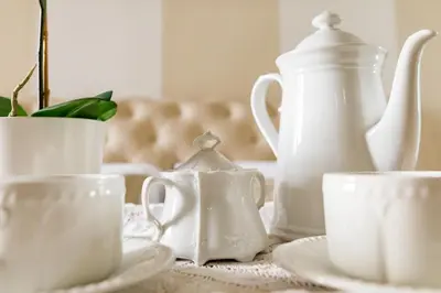 a group of white cups and saucers on a table at Frattina Royal in Rome