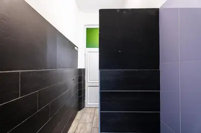 a bathroom with black tiles and a black wall at BigFamilyRome - Testaccio Riverside in Rome