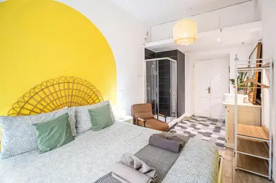 a bedroom with a large bed and a yellow wall at BigFamilyRome - Testaccio Riverside in Rome