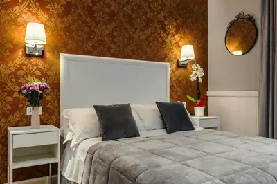 a bedroom with a bed and two tables with flowers at Bed And Best in Rome