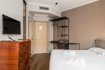 a bedroom with a bed with a dresser and a television at The Place in Rome