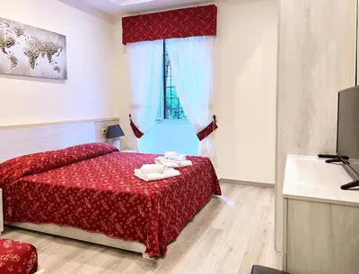 a bedroom with a red bed and a window at Casa Vacanza Vahid in Rome