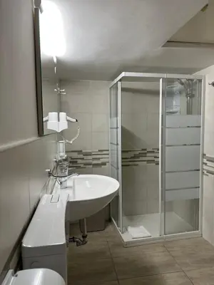 a white bathroom with a shower and a sink at Casa Vacanza Vahid in Rome