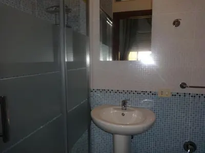 a bathroom with a sink and a shower with a mirror at B&B Twins in Rome