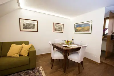 a dining room with a table and a green couch at AmoRoma Francesca in Rome