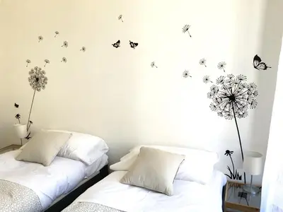 two beds in a bedroom with butterflies on the wall at Le Rondini a Roma in Rome