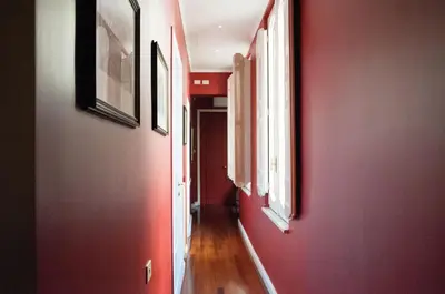 a hallway with red walls and pictures on the walls at Relais Teatro Argentina in Rome