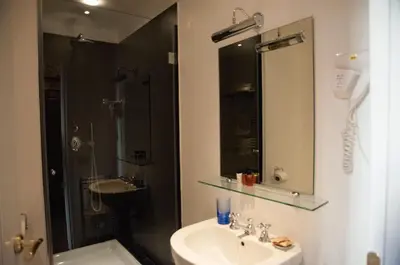 a bathroom with a sink and a shower and a mirror at Relais Teatro Argentina in Rome