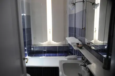a bathroom with a tub and a sink and a window at Relais Teatro Argentina in Rome