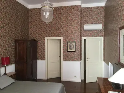 a bedroom with a bed and two white doors at Relais Teatro Argentina in Rome