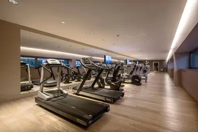 a gym with several tread machines in a room at Ergife Palace Hotel in Rome