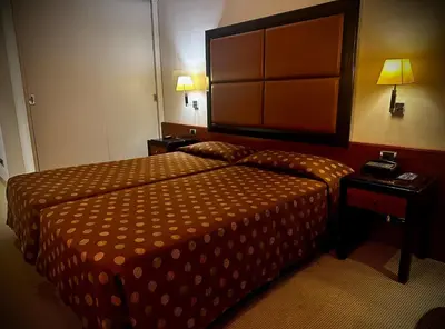 a hotel room with a bed and two lamps at Ergife Palace Hotel in Rome