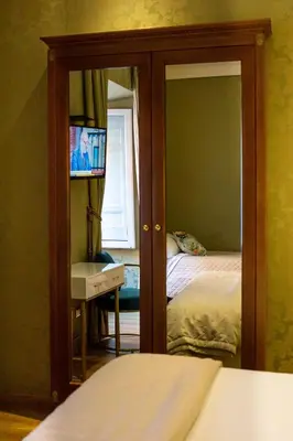 a bedroom with a mirror and a bed and a television at BQ House Trevi Luxury Rooms in Rome