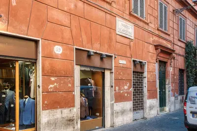 a red brick building with store windows on a street at BQ House Trevi Luxury Rooms in Rome