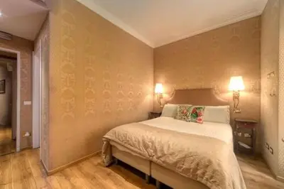a bedroom with a bed with two lamps on the wall at BQ House Trevi Luxury Rooms in Rome